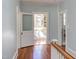 Upstairs hallway features hardwood floors, a charming doorway, and plenty of natural light at 300 Mccauley St, Chapel Hill, NC 27516