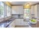 Sun-filled kitchen with a large window above the sink, custom cabinets, granite countertops, and a breakfast nook at 300 Mccauley St, Chapel Hill, NC 27516