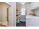 Functional laundry room with washer, dryer, shelving, storage cabinets, and a window for natural light at 300 Mccauley St, Chapel Hill, NC 27516
