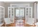 Bright office space with hardwood floors, French doors, and natural light from a window overlooking the yard at 300 Mccauley St, Chapel Hill, NC 27516