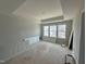 Bedroom featuring a tray ceiling, a large window with a view of the neighborhood at 307 Chesapeake Commons St # 100, Garner, NC 27529