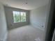 Bedroom featuring neutral paint, blank canvas, and a new window overlooking the tree line at 307 Chesapeake Commons St # 100, Garner, NC 27529