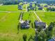 Expansive aerial view showcasing a luxury home with a long driveway and meticulously manicured landscaping at 309 Shoreline Dr, Princeton, NC 27569