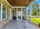 Covered back porch with brick accents and access to outdoor spaces at 309 Shoreline Dr, Princeton, NC 27569