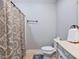 Well-lit bathroom with patterned shower curtain, tile floors, and classic toilet and vanity at 309 Shoreline Dr, Princeton, NC 27569
