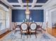 Elegant dining room with wainscoting, coffered ceiling, chandelier, and ample seating for formal gatherings at 309 Shoreline Dr, Princeton, NC 27569