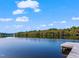 Dock view on a serene lake on a sunny day with light cloud cover at 309 Shoreline Dr, Princeton, NC 27569