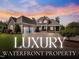 Stunning brick waterfront home featuring manicured landscaping, stone accents, and a circular driveway at 309 Shoreline Dr, Princeton, NC 27569