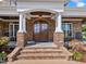 Inviting front entrance with stone accents, white columns, and a beautiful stained wood door at 309 Shoreline Dr, Princeton, NC 27569