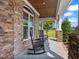 Charming front porch with rocking chairs, brick accents, and peaceful views of the lawn and sky at 309 Shoreline Dr, Princeton, NC 27569