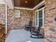 Relaxing front porch with rocking chairs, stone columns, and a brick facade perfect for enjoying the view at 309 Shoreline Dr, Princeton, NC 27569