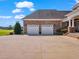 Spacious three-car garage with brick exterior and white doors, providing ample parking and storage at 309 Shoreline Dr, Princeton, NC 27569