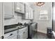 Well-organized laundry room featuring a granite sink, modern washer/dryer, and ample cabinet space at 309 Shoreline Dr, Princeton, NC 27569