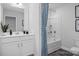 This bathroom features a bathtub with shower, stylish blue curtains, and modern vanity at 31 Priming Way, Angier, NC 27501