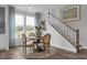 Cozy dining area with a round table, comfortable chairs, and a decorative staircase at 31 Priming Way, Angier, NC 27501