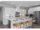An angled view showcases this kitchen's spacious island with sink, stainless steel appliances, and pendant lights at 31 Priming Way, Angier, NC 27501