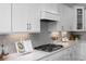 A detailed view highlights the gas cooktop, stylish backsplash, and quartz countertops in this kitchen at 31 Priming Way, Angier, NC 27501