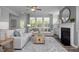 Spacious living room with comfortable seating, a fireplace, and large windows with natural light at 31 Priming Way, Angier, NC 27501