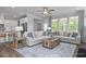 Bright living room with a comfortable sectional sofa, large windows, and a decorative area rug at 31 Priming Way, Angier, NC 27501