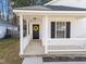 Cozy front porch with white railings and a welcoming yellow wreath on the black front door at 312 Homestead Park Dr, Apex, NC 27502
