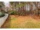 Expansive backyard with mature trees, a grassy area, and a white picket fence at 3122 Coxindale Dr, Raleigh, NC 27615