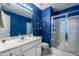 Modern bathroom with blue walls, glass-enclosed shower, and vanity at 3122 Coxindale Dr, Raleigh, NC 27615