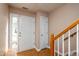 Bright foyer featuring a white front door, wood floors, and staircase with wooden railing at 3122 Coxindale Dr, Raleigh, NC 27615