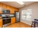 A fully equipped kitchen featuring stainless steel appliances, ample wood cabinetry, and laminate flooring at 3122 Coxindale Dr, Raleigh, NC 27615