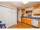 Traditional kitchen featuring wood cabinets, laminate countertops, white appliances, and wood laminate flooring at 3122 Coxindale Dr, Raleigh, NC 27615