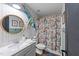 Colorful bathroom with a pedestal sink, toilet, and shower with a floral curtain at 3124 Elm Tree Ln, Raleigh, NC 27614