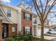 Exterior view of brick townhome with black shutters, white garage door and manicured shrubbery at 3124 Elm Tree Ln, Raleigh, NC 27614