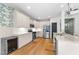 Bright kitchen with stainless steel appliances, white cabinetry, and hardwood flooring at 3124 Elm Tree Ln, Raleigh, NC 27614
