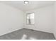 A bright room with gray carpet features a single window, electrical outlets, and white walls at 325 Bainbridge Cir, Garner, NC 27529