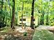 Charming yellow two-story home surrounded by lush trees and greenery, providing a serene and private setting at 325 Bainbridge Cir, Garner, NC 27529