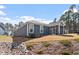 Back exterior of blue home includes a screened-in porch and outdoor space with a rocky landscaped area at 3424 Writt Ct, New Hill, NC 27562
