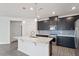 Modern kitchen with dark cabinets, a quartz island, stainless steel appliances, and stylish backsplash at 3424 Writt Ct, New Hill, NC 27562