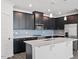 Modern kitchen with dark cabinets, a quartz island, stainless steel appliances, and stylish backsplash at 3424 Writt Ct, New Hill, NC 27562