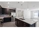 This kitchen features stainless steel appliances, dark cabinets, and an island with pendant lighting at 3424 Writt Ct, New Hill, NC 27562