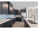 A well-equipped kitchen showcasing stainless steel appliances and sleek, dark cabinetry at 3424 Writt Ct, New Hill, NC 27562