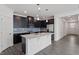 Contemporary kitchen boasts a center island, stainless appliances, and gray wood flooring at 3424 Writt Ct, New Hill, NC 27562