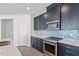 Modern kitchen with dark cabinets, stainless steel appliances, and a light quartz countertop at 3424 Writt Ct, New Hill, NC 27562