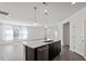 Open-concept kitchen island with stainless steel appliances and plenty of natural light coming from the living area windows at 3424 Writt Ct, New Hill, NC 27562