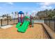 Community playground featuring a colorful play structure with slides and climbing elements, set in a secure, fenced area at 3424 Writt Ct, New Hill, NC 27562