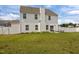 A well-manicured backyard featuring a white privacy fence, patio with seating, and lush green grass at 350 Arlie Ln, Lillington, NC 27546