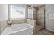 Bathroom featuring tub, glass enclosed shower and a window at 350 Arlie Ln, Lillington, NC 27546