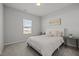 Bright bedroom featuring a cozy bed with decorative pillows, a side table, and a window at 350 Arlie Ln, Lillington, NC 27546