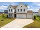 Beautiful two-story home with a three-car garage, stone accents, white siding, and manicured lawn at 350 Arlie Ln, Lillington, NC 27546
