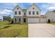 Charming two-story home featuring a three-car garage, stone accents, and a well-maintained lawn at 350 Arlie Ln, Lillington, NC 27546