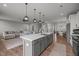 Open-concept kitchen featuring a large island, modern lighting, and seamless flow to the living and dining areas at 350 Arlie Ln, Lillington, NC 27546