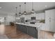 Bright kitchen featuring white cabinetry, stainless steel appliances, and a large island with quartz countertops at 350 Arlie Ln, Lillington, NC 27546
